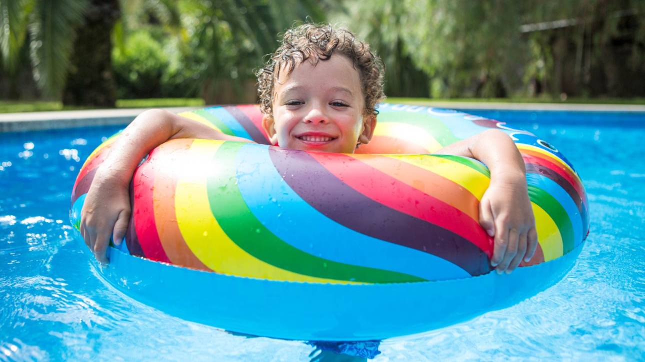 Niño bañándose en la piscina con flotador