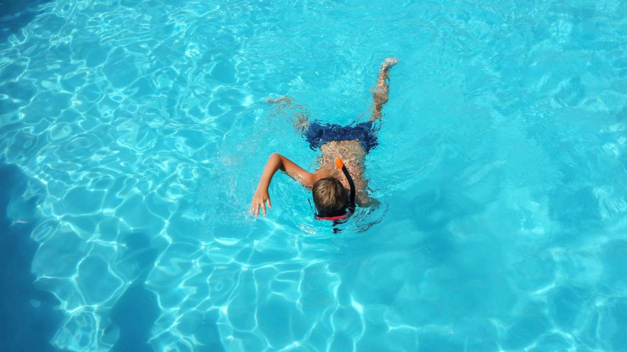 Niño nadando en piscina