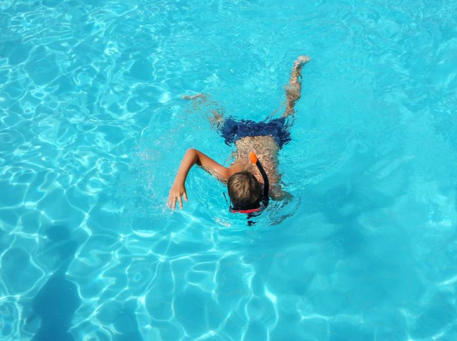 Niño nadando en piscina